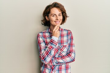 Canvas Print - Young brunette woman wearing casual clothes smiling looking confident at the camera with crossed arms and hand on chin. thinking positive.