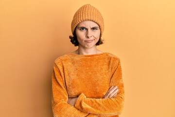 Poster - Young brunette woman wearing wool hat and winter sweater skeptic and nervous, disapproving expression on face with crossed arms. negative person.