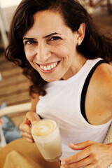 Wall Mural - Woman is sitting in summer cafe on the beach