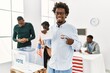 © Krakenimages.com - Young american voter man smiling happy pointing with finger to i voted badge at electoral center.