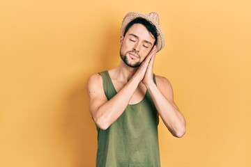 Canvas Print - Young hispanic man wearing summer hat sleeping tired dreaming and posing with hands together while smiling with closed eyes.