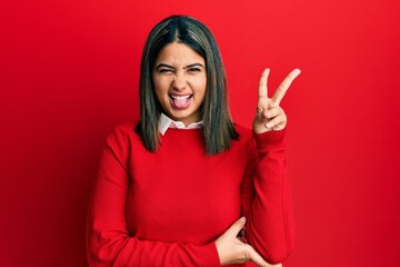 Poster - Young latin woman wearing casual clothes smiling with happy face winking at the camera doing victory sign. number two.