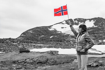 Sticker - Woman holds norwegian flag in mountains Norway