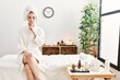 © Krakenimages.com - Young blonde woman wearing bathrobe at wellbeing spa asking to be quiet with finger on lips. silence and secret concept.