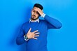 © Krakenimages.com - Young hispanic man with beard wearing casual blue sweater touching forehead for illness and fever, flu and cold, virus sick
