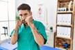 © Krakenimages.com - Young physiotherapist man working at pain recovery clinic ready to fight with fist defense gesture, angry and upset face, afraid of problem