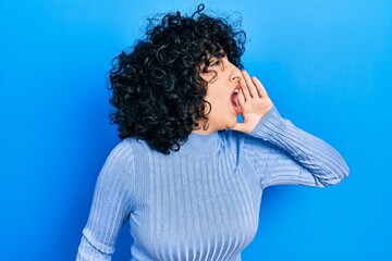 Poster - Young middle east woman wearing casual clothes shouting and screaming loud to side with hand on mouth. communication concept.