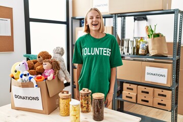 Sticker - Young caucasian woman wearing volunteer t shirt at donations stand winking looking at the camera with sexy expression, cheerful and happy face.