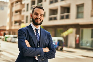 young businessman smiling happy with arms crossed at the city.