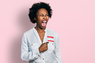 Poster - African american woman with afro hair wearing hello my name is sticker identification angry and mad screaming frustrated and furious, shouting with anger. rage and aggressive concept.