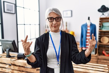 Poster - Middle age grey-haired woman working as manager at retail boutique shouting with crazy expression doing rock symbol with hands up. music star. heavy concept.