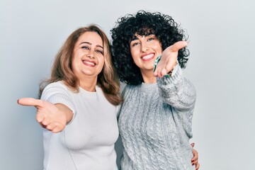 Sticker - Middle east mother and daughter wearing casual clothes smiling friendly offering handshake as greeting and welcoming. successful business.