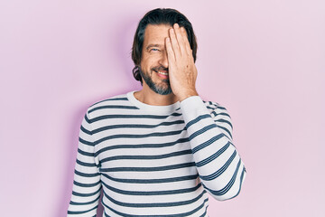 Sticker - Middle age caucasian man wearing casual clothes covering one eye with hand, confident smile on face and surprise emotion.