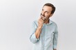© Krakenimages.com - Middle age hispanic man with beard standing over isolated background with hand on chin thinking about question, pensive expression. smiling with thoughtful face. doubt concept.