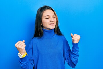 Sticker - Young brunette girl wearing turtleneck sweater very happy and excited doing winner gesture with arms raised, smiling and screaming for success. celebration concept.