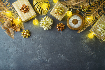 Christmas holiday concept with gift boxes and creative golden decorations. Palm leaves and pineapple ornament background