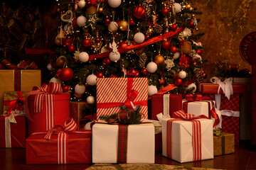 Red,white, gold boxes with gifts near the christmas tree.Christmas background