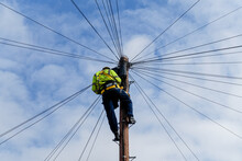 Telecommunications, Telecom Engineer At Work On The Top Of A Telegraph Pole