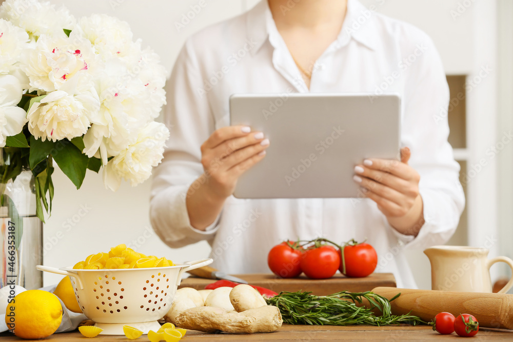 Colander with raw pasta, lemon and ginger on table in kitchen, closeup