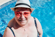 © Westend61 - Happy senior woman wearing sunglasses in swimming pool