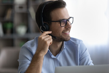 Wall Mural - smiling young business man in eyeglasses wearing headset with mic, listening educational lecture loo
