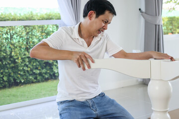 Wall Mural - Asian man assembling white table furniture at home