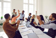 © Studio Romantic - Diverse team of happy euphoric ecstatic mixed race multiethnic people sitting at office table, celebrating increasing sales, applauding their leader. Business, teamwork, success, recognition concept