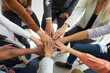 © Studio Romantic - Stack of hands. Young motivated people fold their hands on each other symbolizing their unity and support. Close up of hands of multiracial people sitting in circle. Unity and teamwork concept.