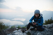 © Westend61 - Happy young woman text messaging through smart phone on mountain