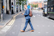 © Westend61 - Businessman using mobile phone while crossing road