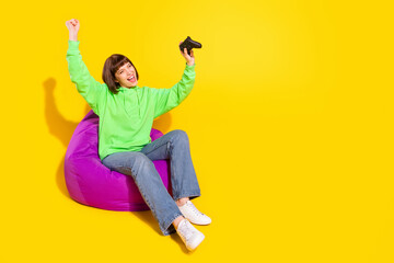 Sticker - Portrait of attractive cheerful girl playing video game having fun isolated over bright yellow color background