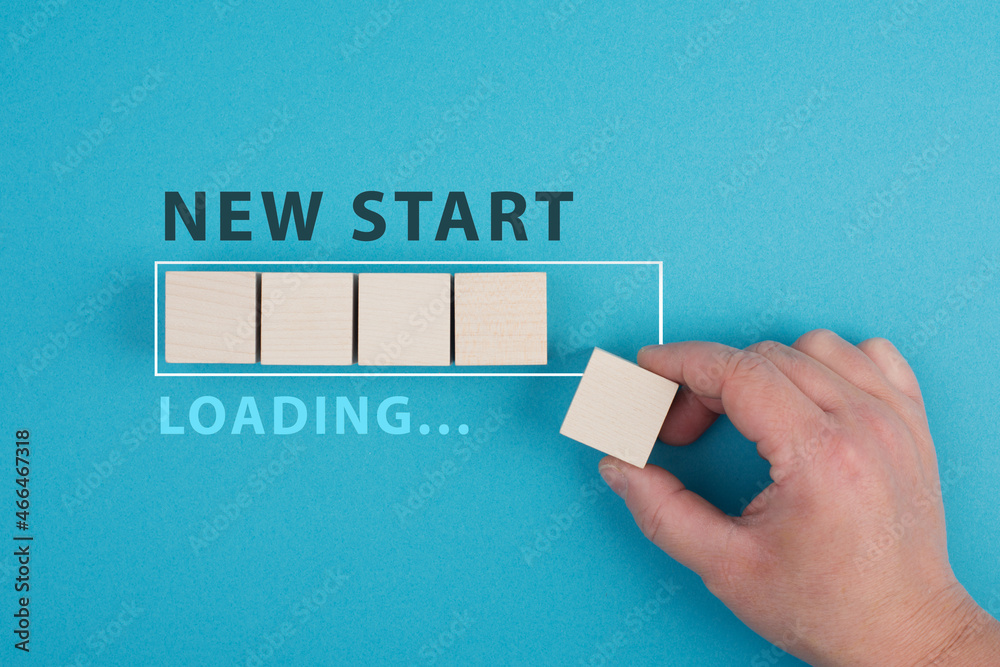 Words new start with a loading bar, hand puts last wooden cube on the ...