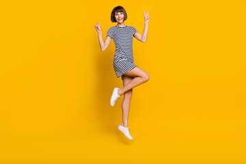 Canvas Print - Full size photo of joyful millennial lady jump show v-sign wear striped dress sneakers isolated on yellow background