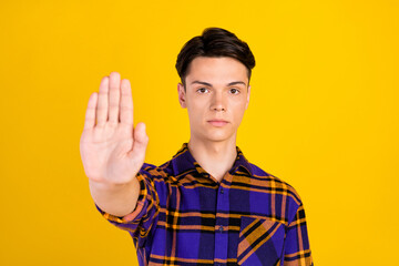 Poster - Photo of strict brunet millennial guy show stop wear checkered shirt isolated on yellow color background