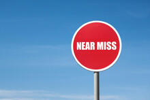 'Near Miss' Sign In Red Round Frame On Sky Background