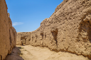 Wall Mural - Street in settlement of Buddhist monks on Kara-Tepe hill, Termez, Uzbekistan. Village existed in 1st-4th centuries. Entrances to living and storage areas are visible on sides of walls