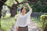 Fototapeta Nowy Jork - 遊歩道の真ん中で手を振るミドル世代の日本人女性