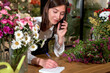 Caucasian Woman Florist Small Business Flower Shop Owner Talk On Phone, Take Orders For Store. Female Gardener Noting Client Order During Mobile Phone Conversation. Handmade, Craft Concept