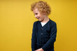© alfa27 - Nice preschool boy posing isolated over yellow studio background. Curly kid in casual clothes looking down. Concept of facial expressions, childhood, education, family. Copy space for ad