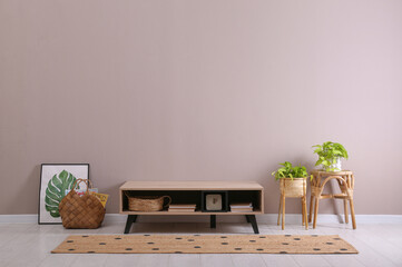 Poster - Elegant room interior with wooden cabinet and beautiful houseplants near beige wall. Space for text