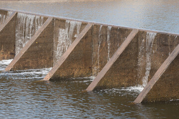 The water flow pass the weir from upper level to lower level.