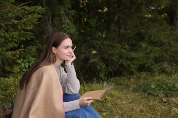 Sticker - Young woman drawing with pencil in sketchbook near forest, space for text