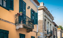 Colorful Facades With Ornate Balconies And Open And Closed Window Shutters Of Traditional Houses In The Center Of Athens, Greece.