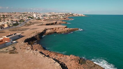 Wall Mural - Drone point of view Torrevieja cityscape, rocky coastline and surf of Mediterranean Sea. Spanish tourist resort town. Vacation and travel concept.  Province of Alicante, Costa Blanca, Spain