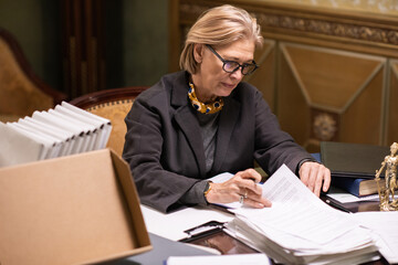 Aufkleber - Blond mature woman in eyeglasses and formalwear looking for particular document while working with juridical or business papers