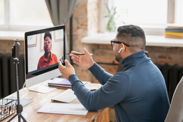 Poster - Confident teacher communicating with young African female student on computer screen during online lesson