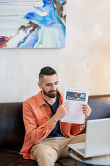 Aufkleber - Confident young man pointing at financial paper while sitting in front of laptop and explaining information during presentation
