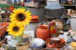 Pottery, sunflower and other junk at a flea market. Blurred background