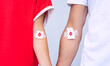 Blood donation. Man and woman blood donors with bandage after giving blood. Save lives. World blood donor day concept