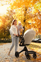 Canvas Print - Happy mother walking with her daughter and stroller on city street